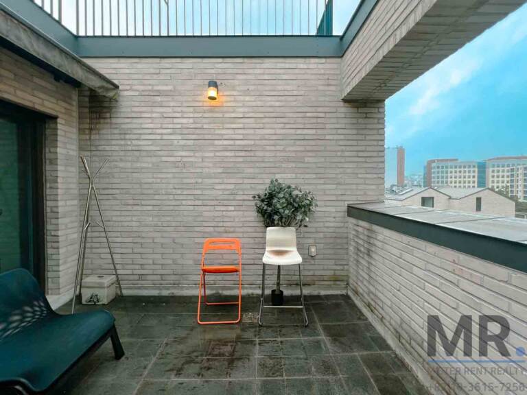 Private terrace with gray brick walls, outdoor chairs and potted plant