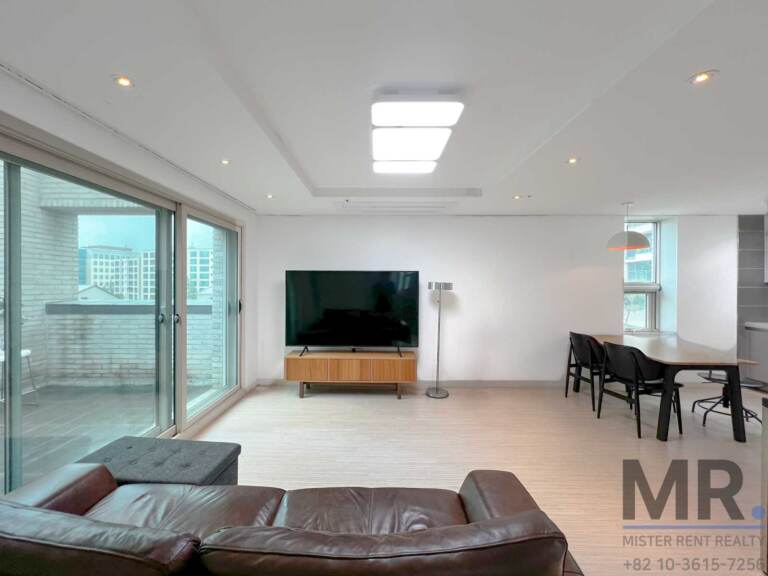 Open living and dining space with large windows and city view