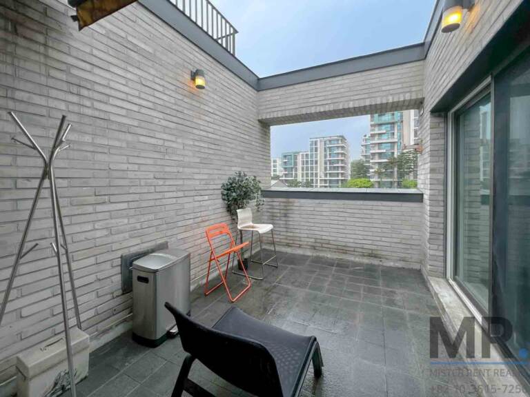 Paved terrace with lounge chair and sliding doors back into the living room