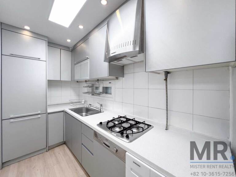Gray kitchen with gas cooktop, range hood and white tiles