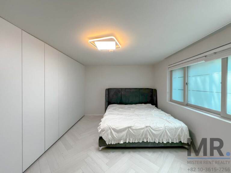 Bedroom with double bed, full-height white wardrobes and window