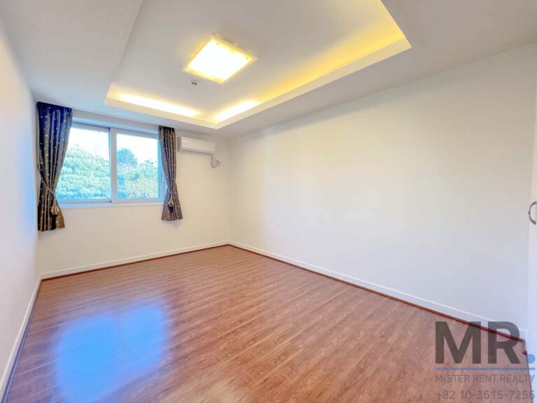Bedroom with blue curtains and wall air conditioner