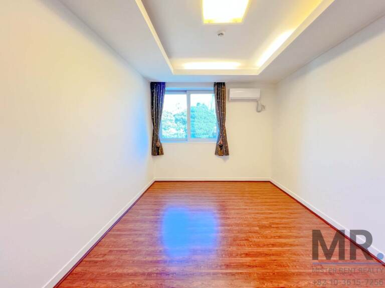 Bedroom with tray ceiling, curtains and window onto trees