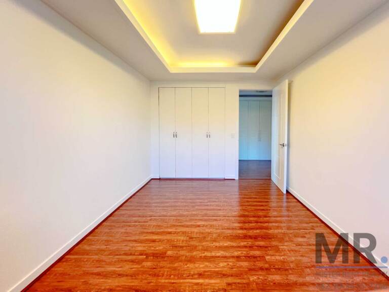 Bedroom with wood floor and built-in white wardrobe