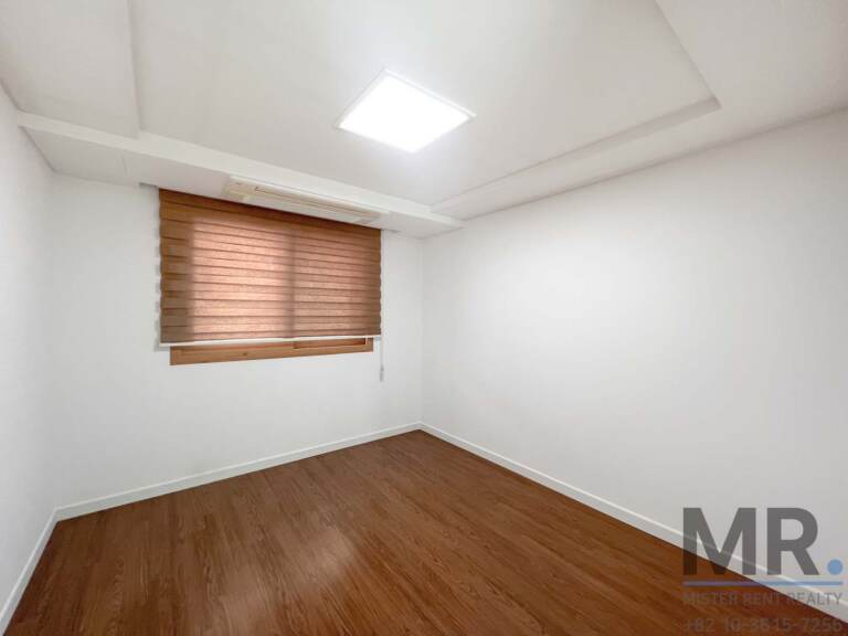 Small bedroom with wooden blinds and dark wood floor