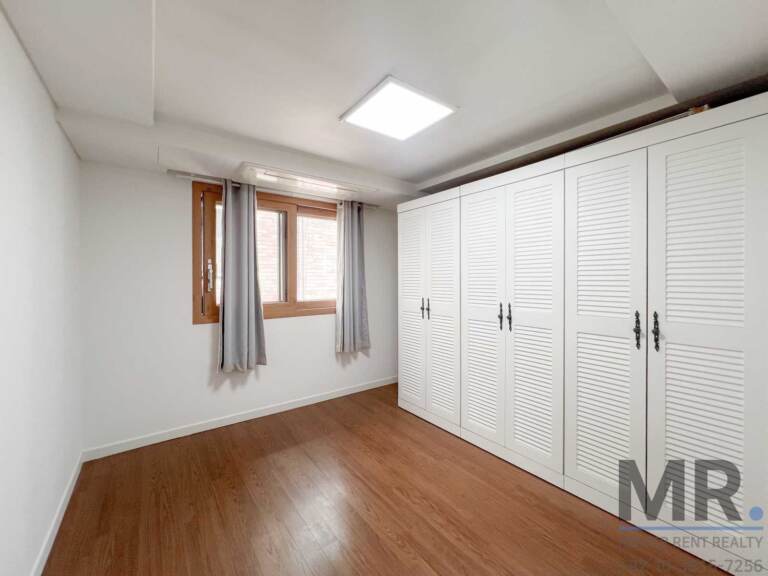 Bedroom with gray curtains and large louvered wardrobe