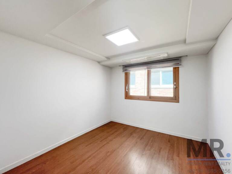 Bedroom with wood-framed window and roman shade