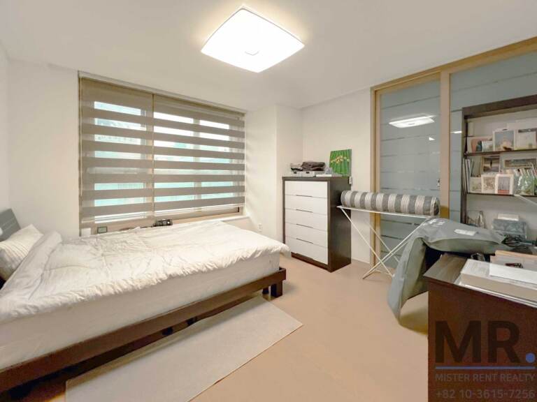 Bedroom with single bed, white dresser and frosted glass doors