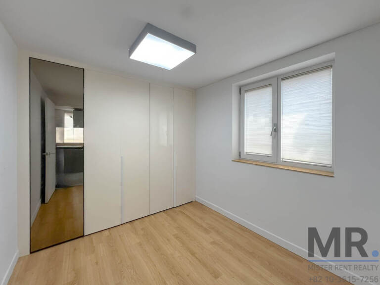Bedroom with white built-in wardrobe and mirrored door