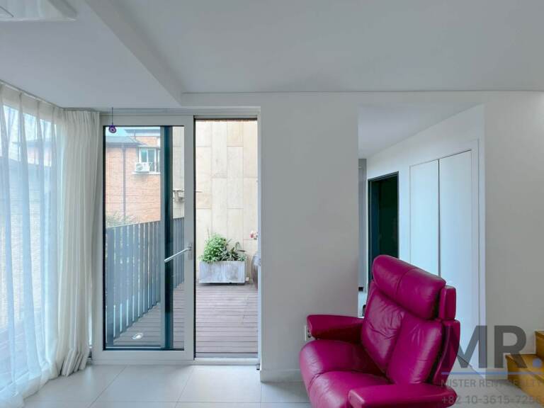 Sitting area with glass doors to a wooden-deck balcony