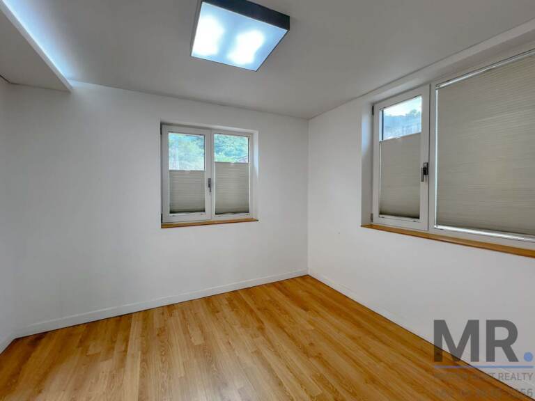 Empty bedroom with oak floors and windows on two sides