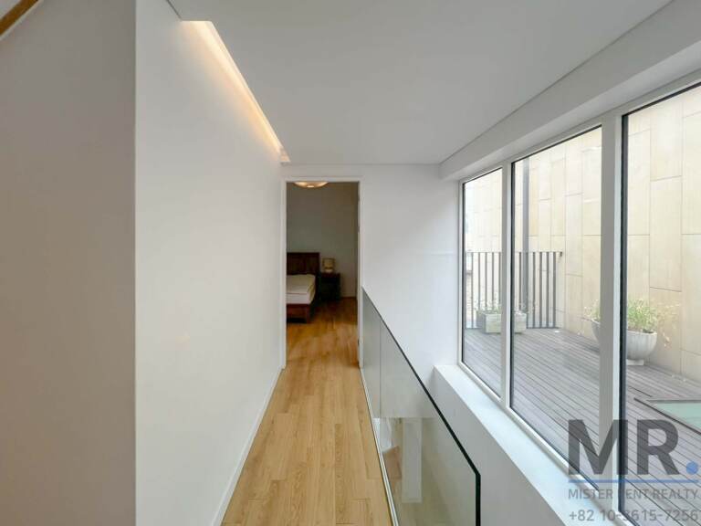Upstairs hallway with glass railing and windows to the terrace