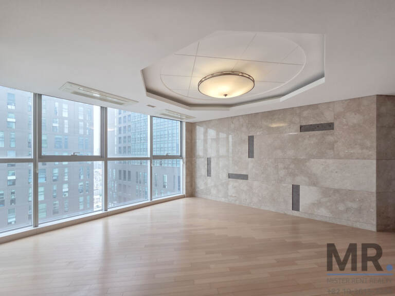 Empty living room with marble-look accent wall and high-rise view
