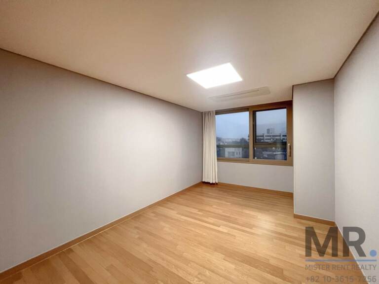 Bedroom with light wood floor and ceiling panel light