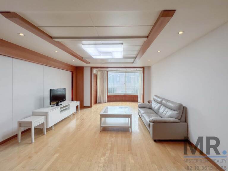 4-bedroom apartment for rent near Gyeongbokgung Palace, Seoul – living room with leather sofa, wood trim ceiling and wide window