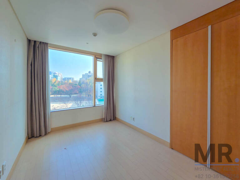 Bedroom with wooden sliding wardrobe and large window