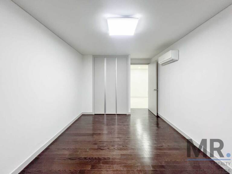 Long bedroom with built-in wardrobe and air conditioner