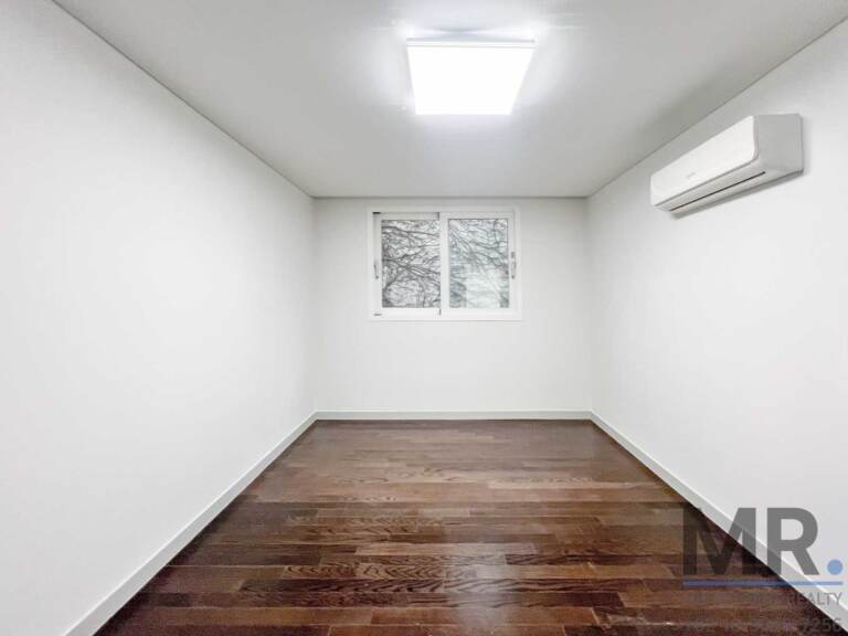 Small bedroom with dark wood floor and window