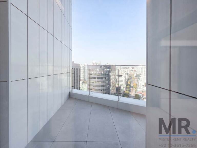 Corner balcony with tiled floor and view down a tree-lined avenue