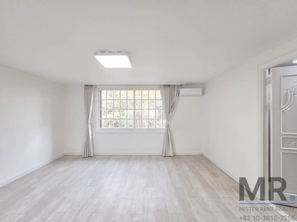 Bedroom with light wood floor, curtained grid window and air conditioner
