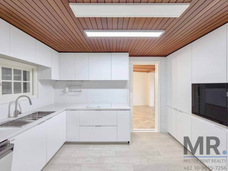 Kitchen with white cabinets, built-in oven and wood slat ceiling