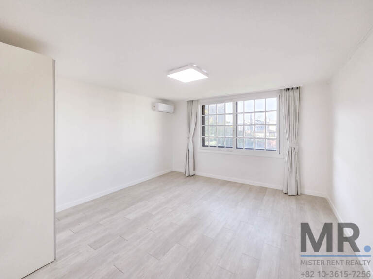 Bright bedroom with built-in wardrobe and window with neighborhood view