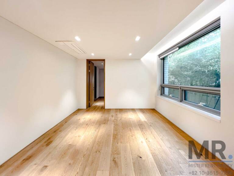 Room with large corner window and wide-plank oak floor