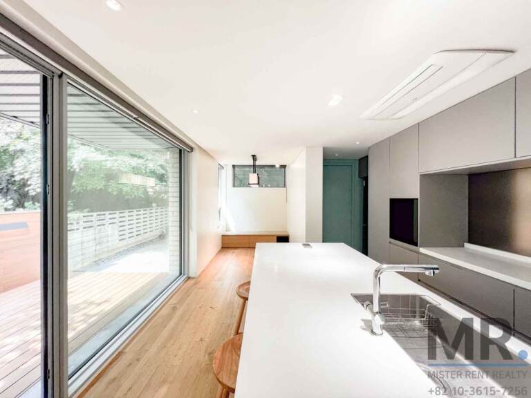Kitchen with white island sink and sliding doors to the wooden deck